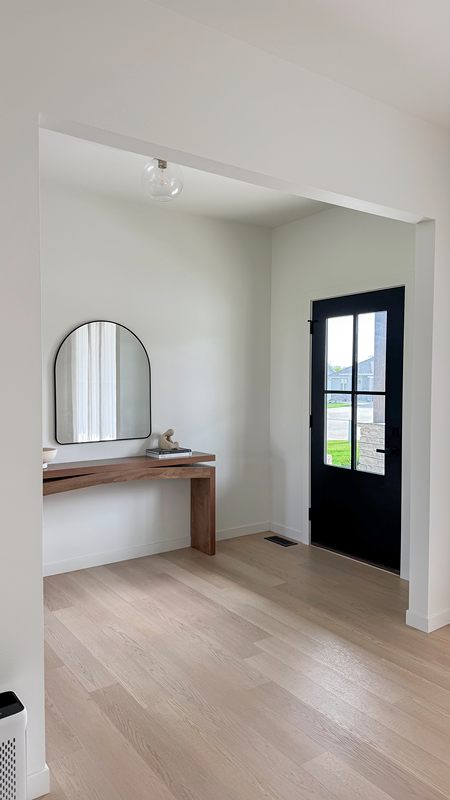 Entryway with light oak floors and a floating shelf