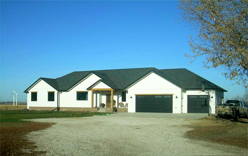 White ranch home with a cedar porch and dark roof